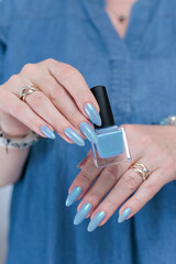 Woman's beautiful hand with long nails and light baby blue manicure	