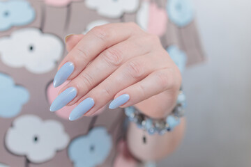 beautiful hand with long nails and light baby blue manicure