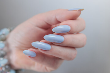 Woman's beautiful hand with long nails and bright blue manicure