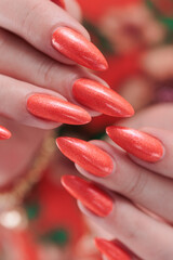 Female beautiful hand with long nails and a bright orange nail polish
