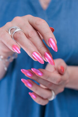 beautiful female hands with long nails and bright neon pink red nail polish
