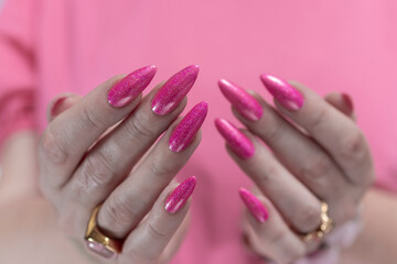 beautiful female hands with long nails and bright neon pink nail polish