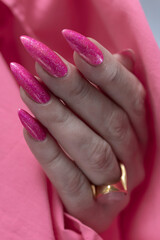 beautiful female hands with long nails and bright neon pink nail polish