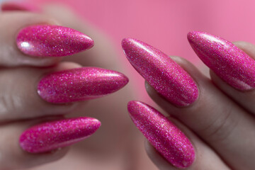 beautiful female hands with long nails and bright neon pink nail polish