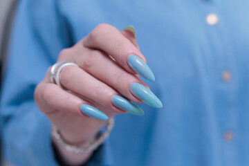 Woman's beautiful hand with long nails and blue manicure