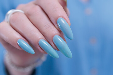 Woman's beautiful hand with long nails and blue manicure