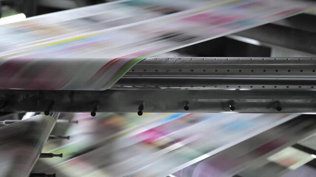 printing machine producing colorful marketing brochures on paper
