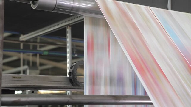 Closeup of printing press producing colorful brochures and daily newspapers

