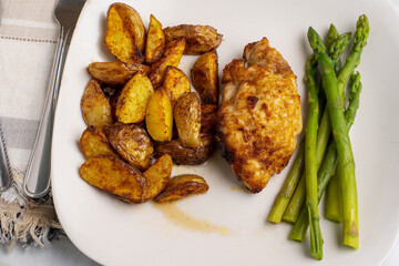  chicken thigh   with  potato wedges and asparagus