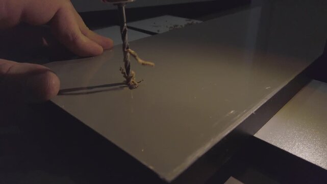 Hand drill making hole in an mdf board. DIY home project