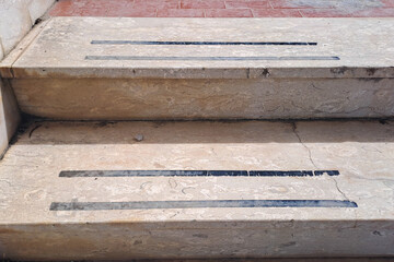 Concrete steps with worn anti-slip strips showing textured surface detail