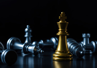 Golden king chess piece standing victorious over fallen silver pieces strategic victory