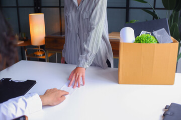 Female employee deliver a resignation letter in a white envelop to her manager or HR department when she decides to quit, resigned from her job.