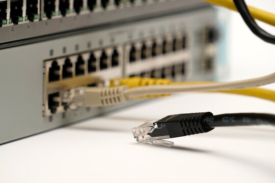 Close-up of a disconnected Ethernet cable lying near active ports of a network switch, symbolizing internet failure, IT troubleshooting, and connectivity issues.