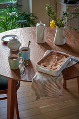 Traditional apple pie on a wooden plate on a light culinary background. Charlotte pie on a platter in closeup. Delicious homemade cakes on the kitchen table