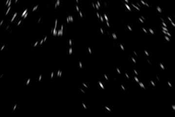Minimal blurred snow overlay on dark, black background. Subtle motion particle texture ideal for adding gentle winter mood. Good to use as photo overlay. Snowfall. Abstract unfocused background