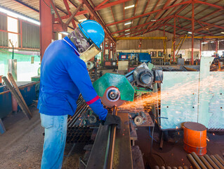 Industrial Worker Cutting Steel Pipe with a CUT-OFF Machine in a Factory, Wearing a Safety Helmet, Gloves, and Protective Gear, Sparks flying from the Cutting Process.