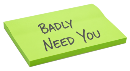 Isolated stack of green notes with handwritten phrase "Badly Need You", top-down perspective