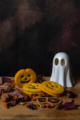 Top view of Halloween cookies with a white ghost, leaves, and nuts, vertically with copy space