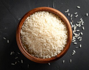 Uncooked White Long Grain Rice in Wooden Bowl on Dark Textured Background

