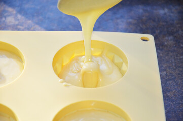 pouring liquid muffin batter into silicone baking mold. making dessert at home. tasty food for kids and adults