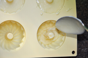 pouring liquid muffin batter into silicone baking mold. making dessert at home. tasty food for kids and adults