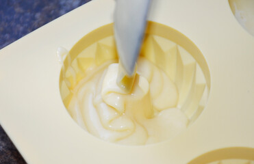 pouring liquid muffin batter into silicone baking mold. making dessert at home. tasty food for kids and adults
