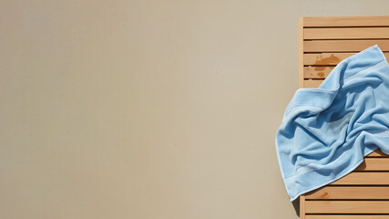 Wet towel on sunbed / sun lounger on a neutral background with copy space