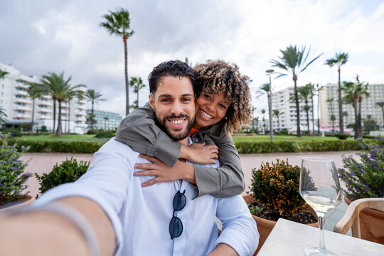 Happy diverse couple having fun taking selfie on travel vacation
