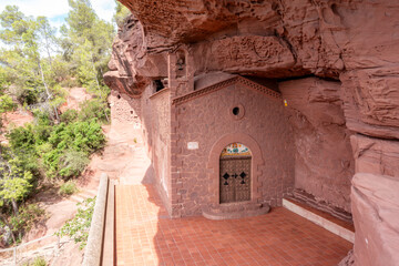 The unique Hermitage of Sant Gregori, a 20th-century chapel built of red sandstone inside a cave near Falset, Catalonia