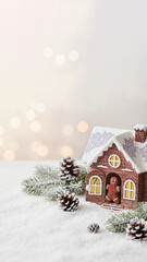 Open-door advent calendar house with chocolate gingerbread man on snowy surface with fir branches and cones bokeh effect copy space
