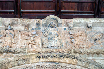 A detailed view of Christ in Majesty on the magnificent 12th-century Romanesque portal of the Santa Maria de Ripoll Monastery, a masterpiece of medieval sculpture. Catalonia, Spain