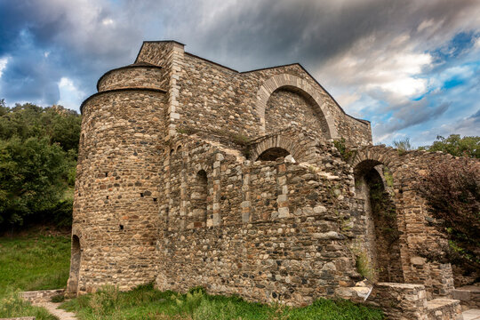 The ancient Romanesque architecture of the historic Sant Serni de Tav&egrave;rnoles monastery under a dramatic, stormy sky in the Catalan Pyrenees