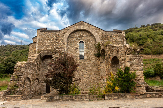 The ancient Romanesque architecture of the historic Sant Serni de Tav&egrave;rnoles monastery under a dramatic, stormy sky in the Catalan Pyrenees