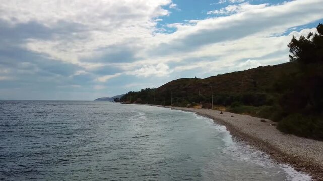 The drone footage shows beauty of G&ouml;kova Bay G&ouml;kova K&ouml;rfezi in Turkey, this footage showcases the pristine coastline with its clear, calm waters, pebble beach, and verdant hills under a partly cloudy 