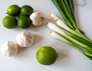 Fresh produce, limes, garlic, and green onions on marble