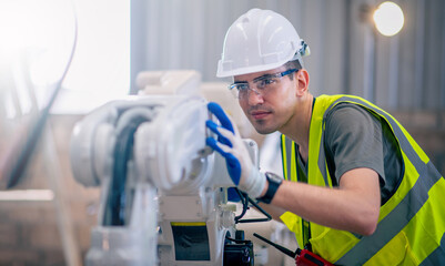 Engineers mechanic using computer controller Robotic arm for welding steel in steel factory workshop. Industry robot programming software for automated manufacturing technology