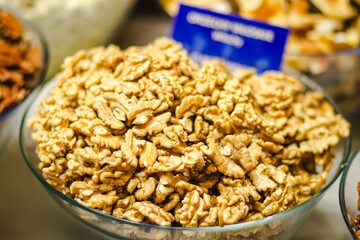 Bowl filled with shelled walnuts, showcasing their rich texture and natural color, surrounded by various nuts, highlighting healthy snacking options and culinary versatility