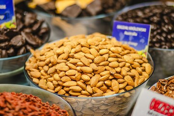Bowl filled with raw almonds surrounded by various nuts and chocolates, showcasing a vibrant display of healthy snacks and indulgent treats for culinary enthusiasts