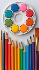 Naklejka premium Vibrant Art Supplies: Watercolors, Colored Pencils, and Brushes on White Background