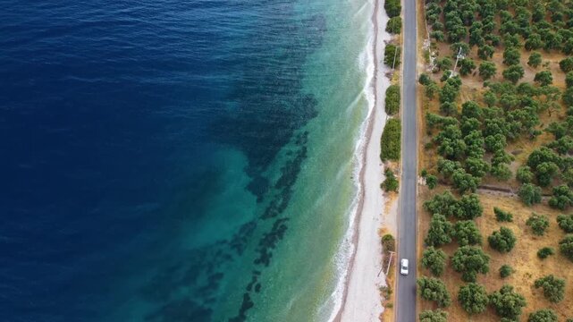 aerial footage showcasing the picturesque coastline of G&ouml;kova Gulf in Turkey, specifically near Bozalan Beach II in &Ccedil;&ouml;kertme, Muğla. The video captures the serene turquoise waters, a pristine white pe