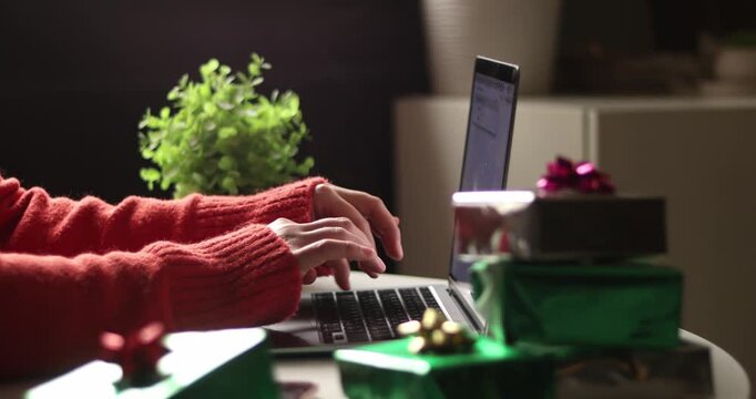 Christmas online shopping, sales and discounts promotions during winter holidays, online shopping at home. Female hands on the laptop typing and shopping new years presents - Powered by Adobe