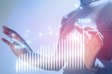 A woman is holding her hand up to a graph that shows a line going up to the year 2026