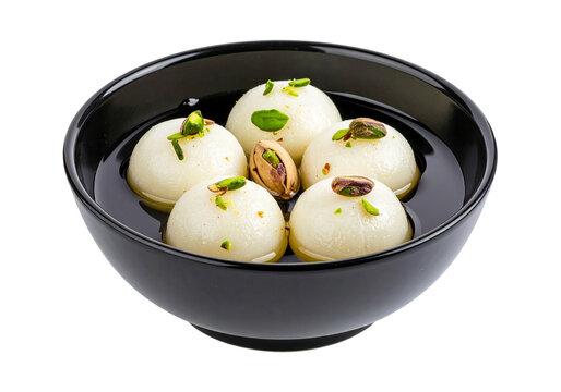 A close up view of rasgulla sweets in a bowl with pistachio garnish on a plain surface view from above on transparent background