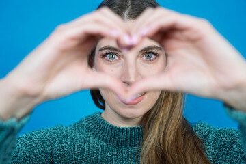 Woman making heart gesture expressing love and affection