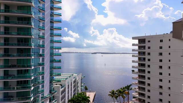 Aerial Brickell Rise. Drone ascent between highrise buildings to view beautiful clouds over Brickell Bay Miami Florida