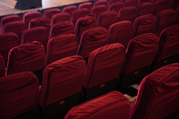 Rows of red theater seats with black armrests