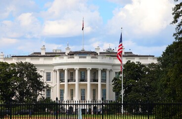 Naklejka premium Washington, DC, USA - August 26, 2025: White House South Lawn view with typical columns American flag in park
