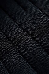 Close up texture of black textile fabric with soft woven pattern showing detailed surface background