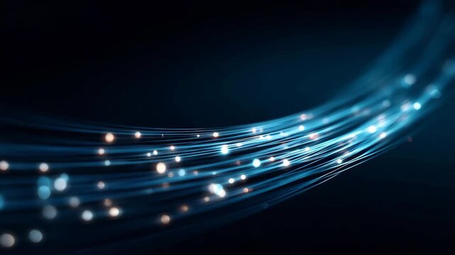 Curved blue glowing fiber optic strands with light particles in dark